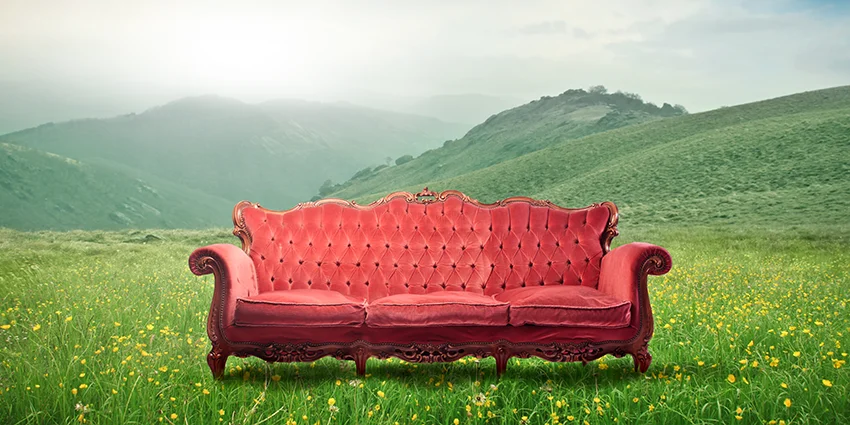 Red sofa in a field